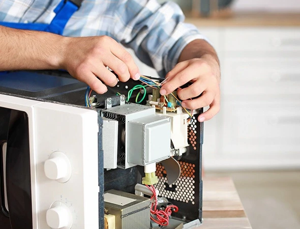 Technician inspecting a residential microwave oven