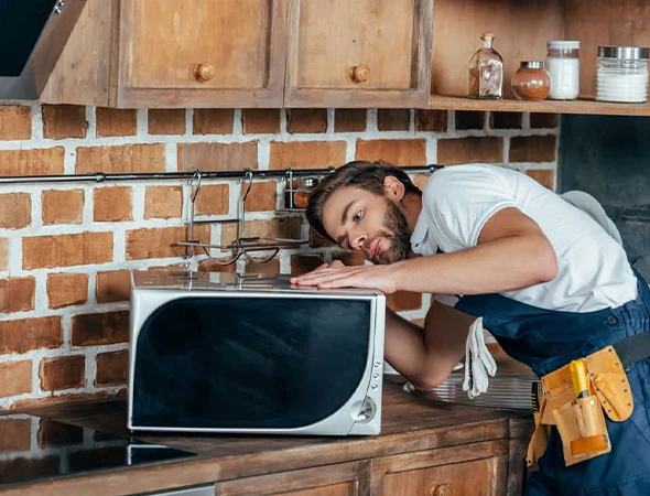 Affordable Appliance technician repairing a home microwave