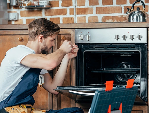 Technician inspecting a residential kitchen range