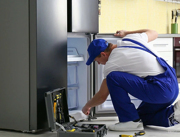 Refrigerator repair technician inspecting a refrigerator in Meridian Idaho