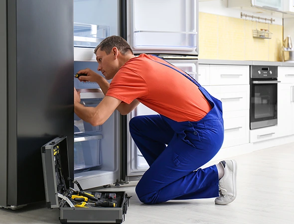 Technician troubleshooting a residential refrigerator