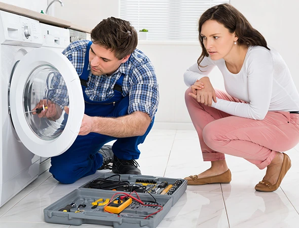 Washer repair technician inspecting a washing machine in Meridian ID