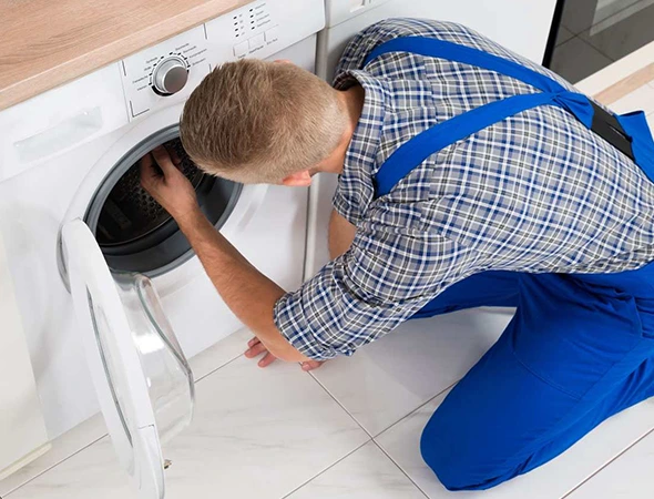 Top load washer repair technician servicing a home appliance